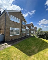 Row of brick houses with green lawn
